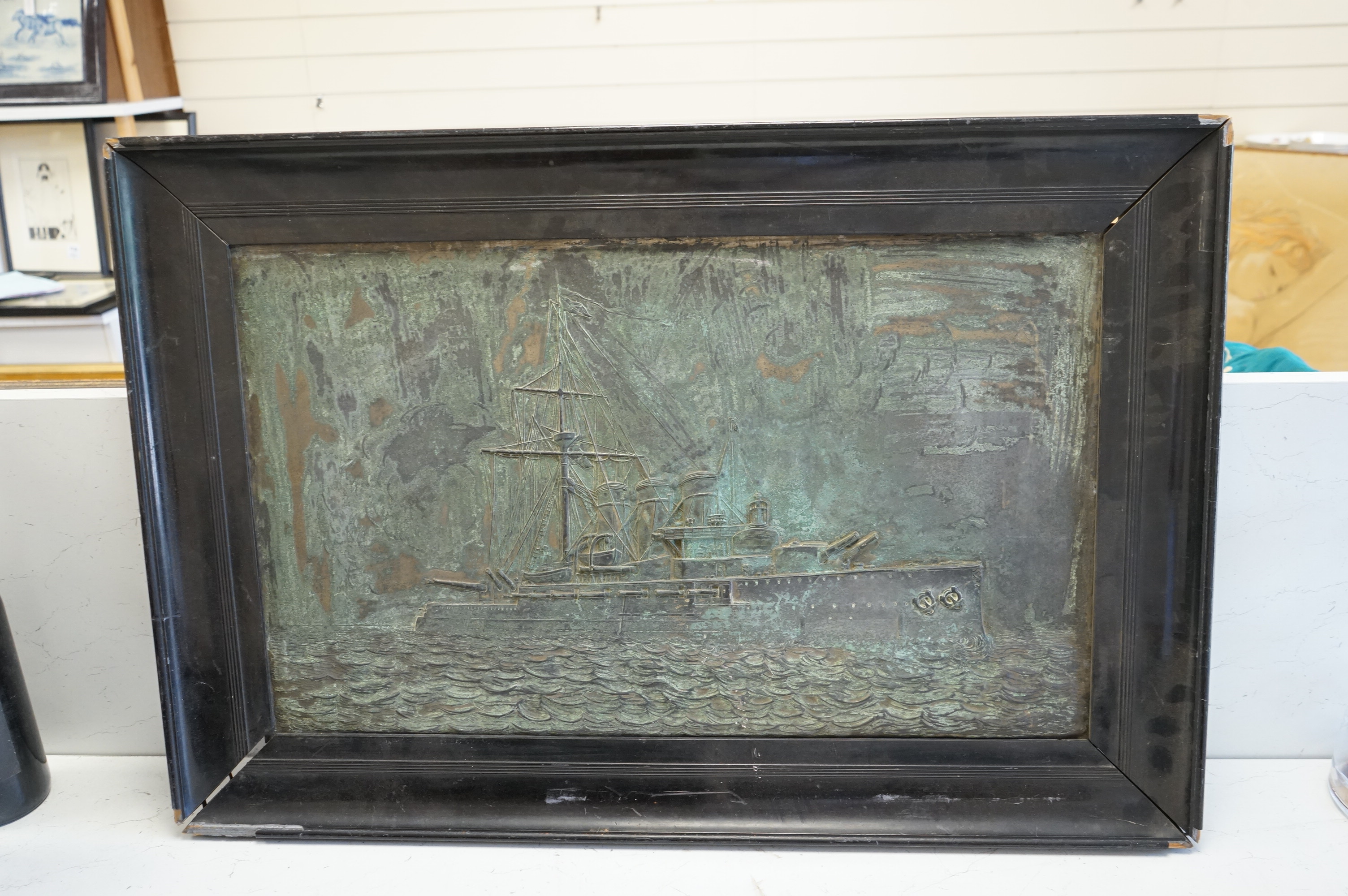 A metal relief panel of a ship, framed, 53cm high